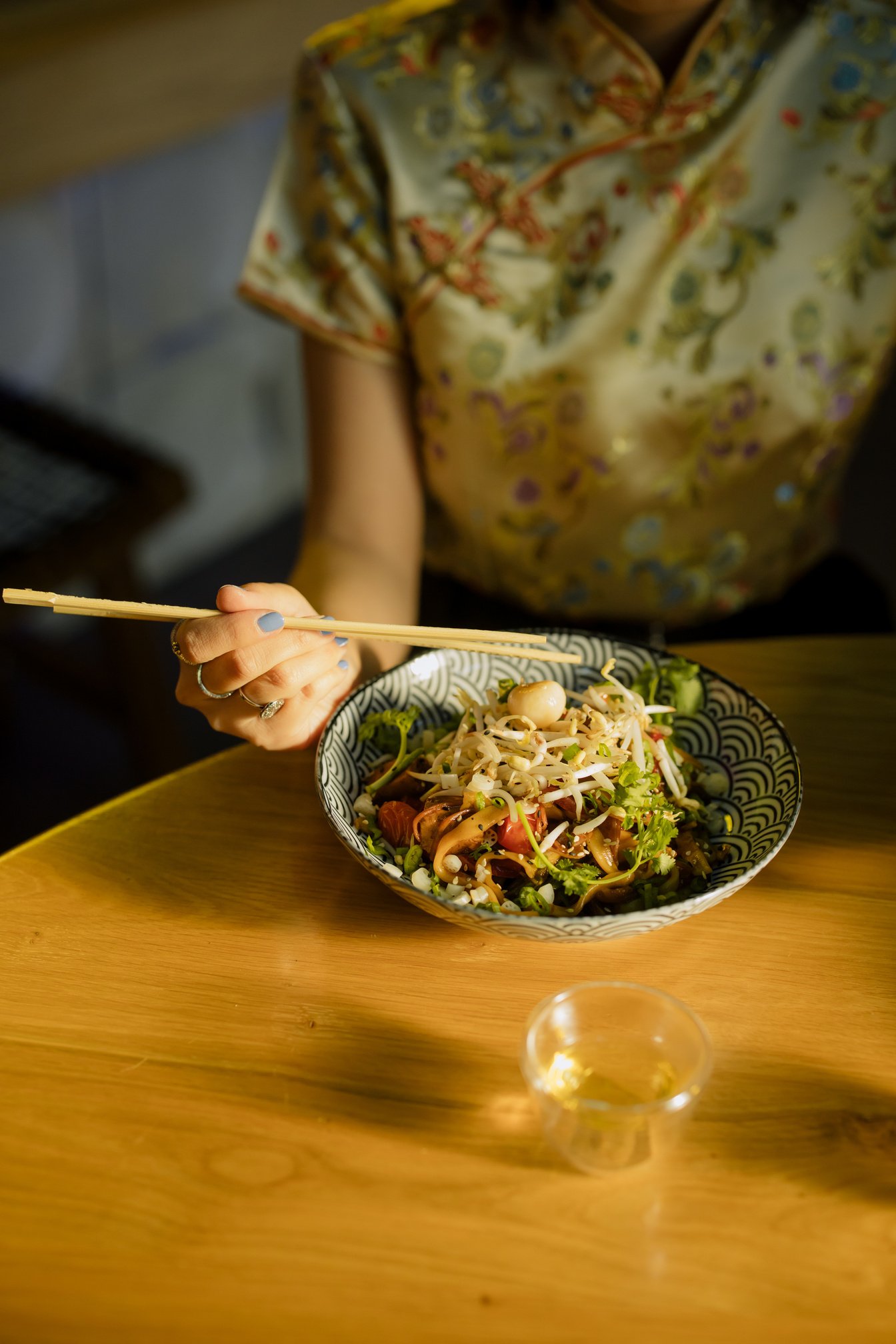 Person Holding Chopsticks Eating Noodles